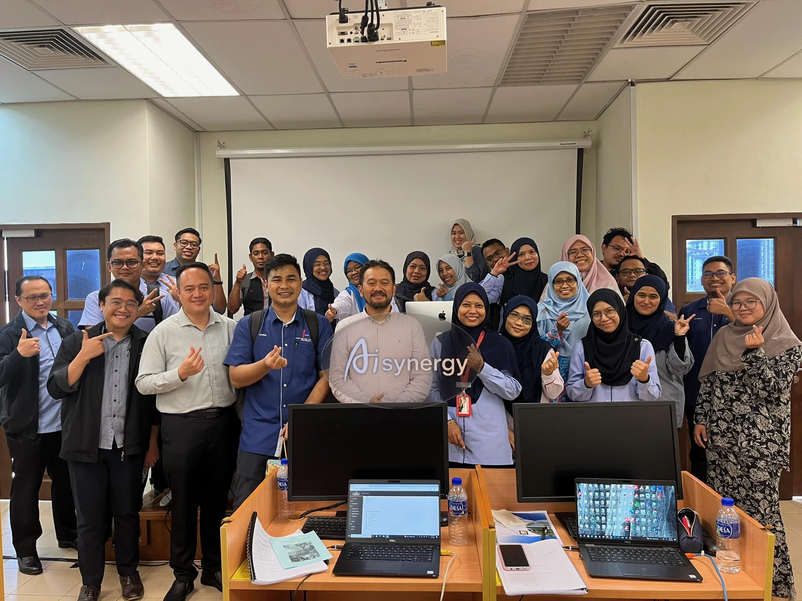 A large group of training participants posing together after a completed session