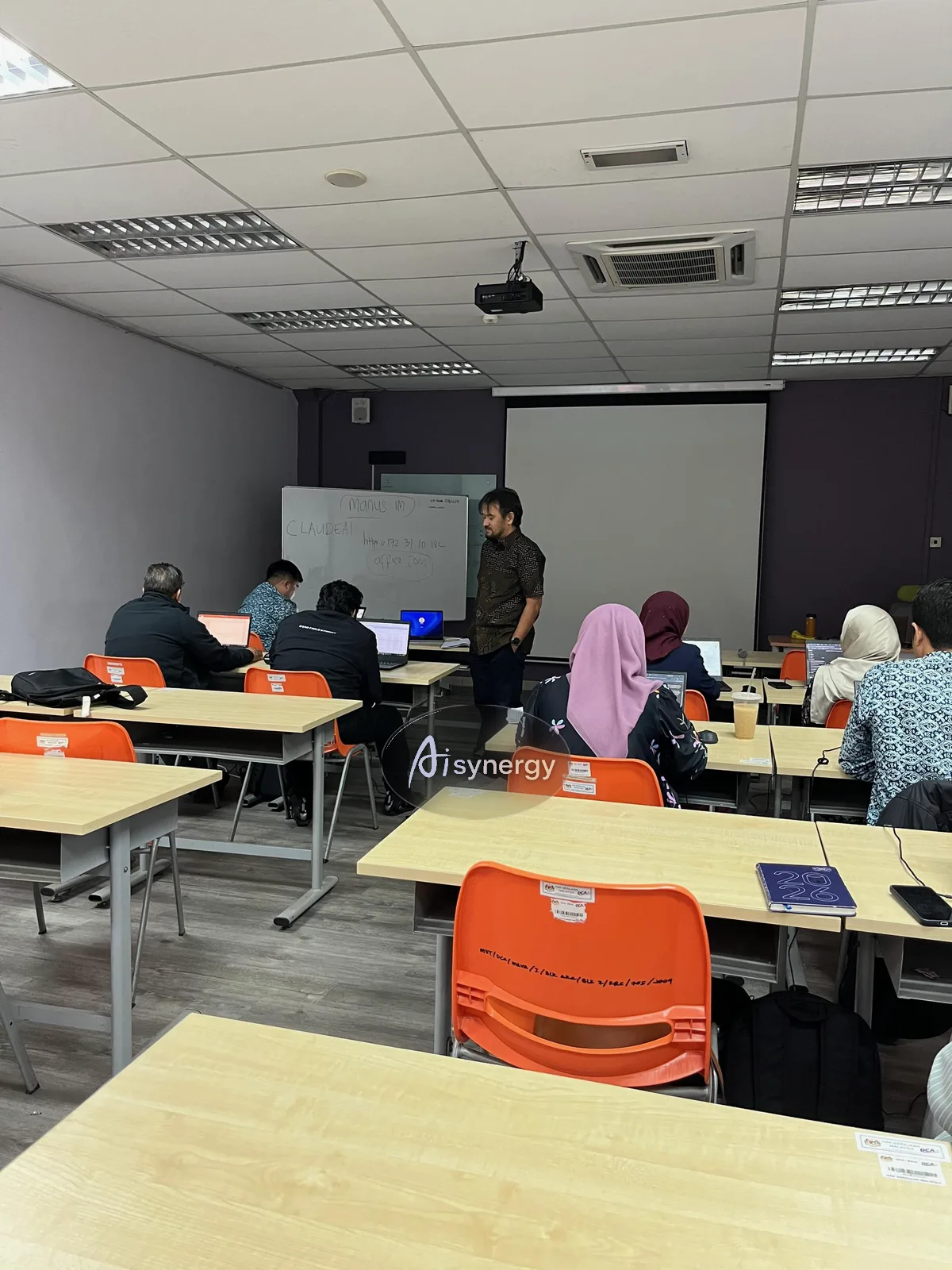 Trainer working through tools at the whiteboard while participants follow on laptops
